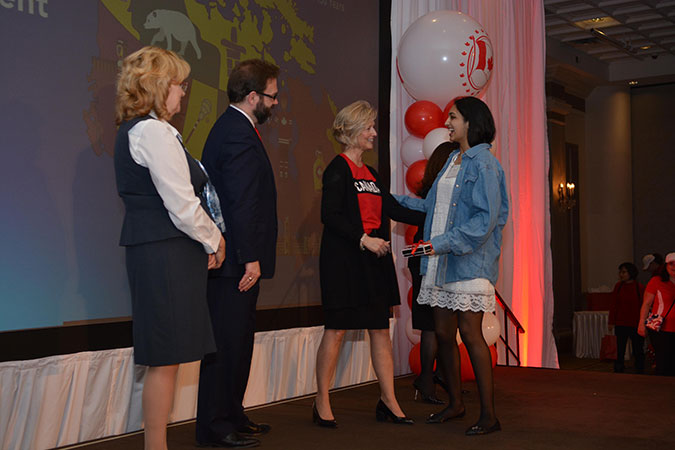 A PLASP volunteer accepts her award from PLASP CEO Lynn Hiebert while Board President Paul Street and Brampton Mayor Linda Jeffrey look on.