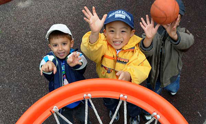 Children throw a basketball into a hoop