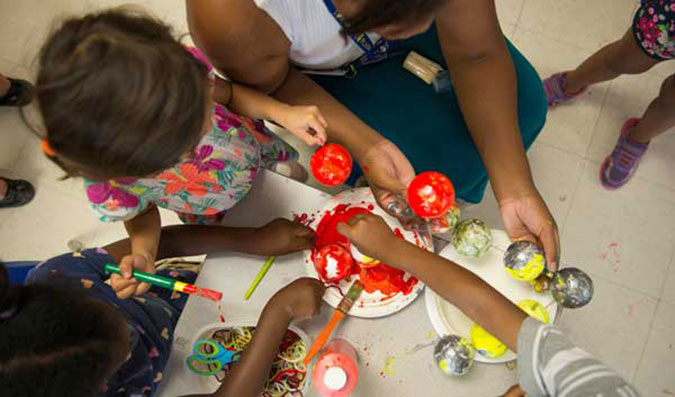 PLASP staff and children painting Styrofoam balls