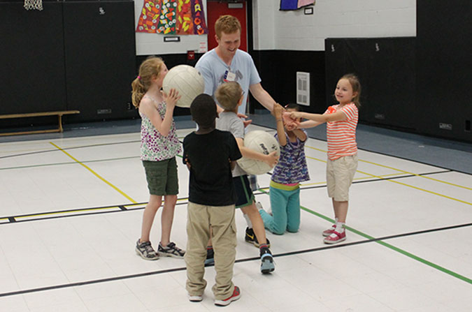Evan with a group of children in a gym