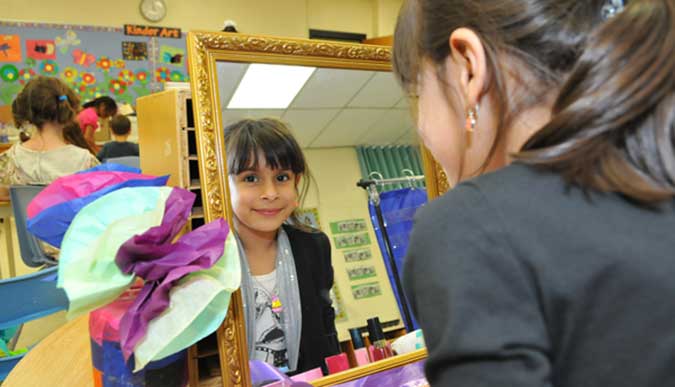 A child looks at a mirror