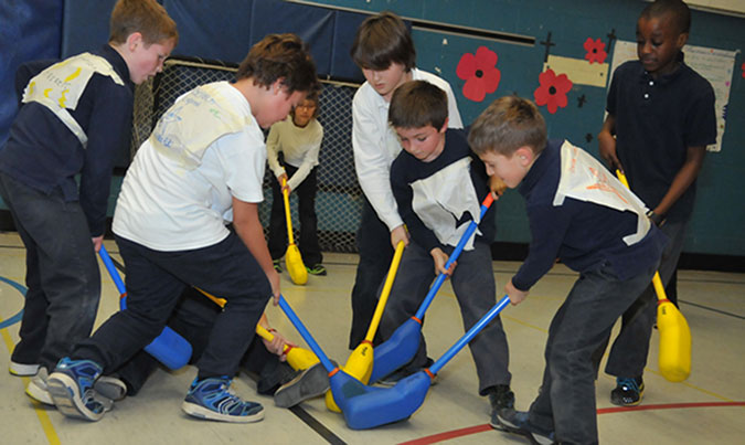 Five children playing floor hockey