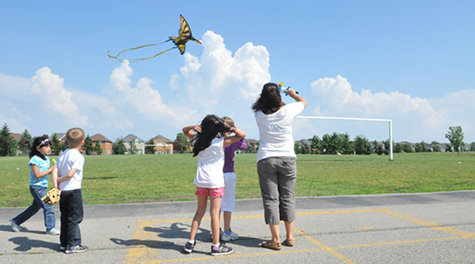 Children and a PLASP staff member fly a kite