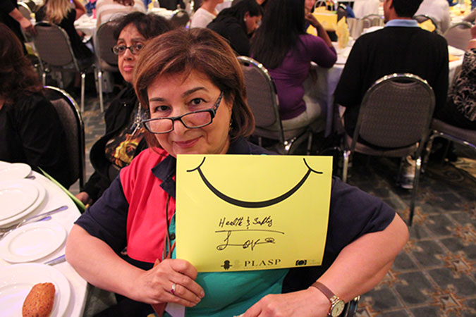 A PLASP staff holds up a yellow card with a smiley