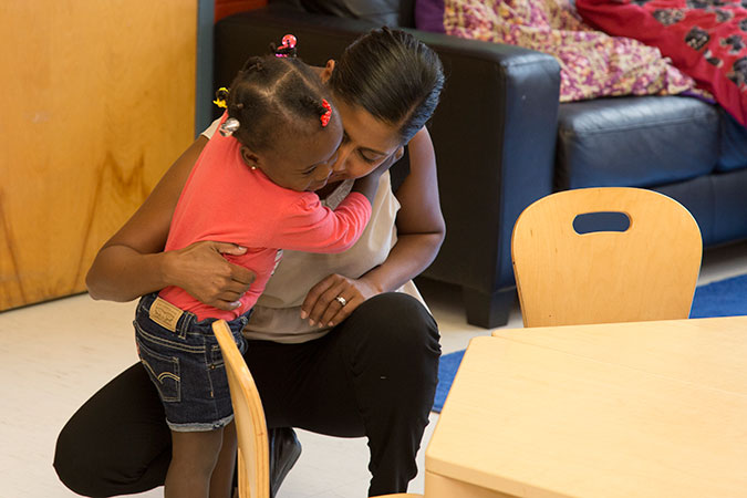 A PLASP staff hugs a child