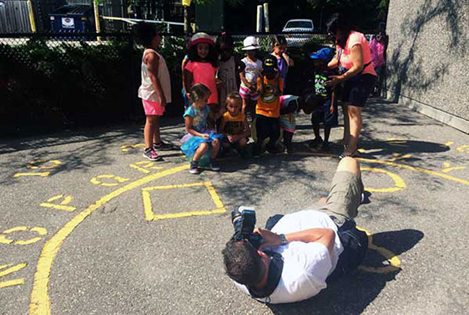 Photographer Stephen Uhraney taking photos of children