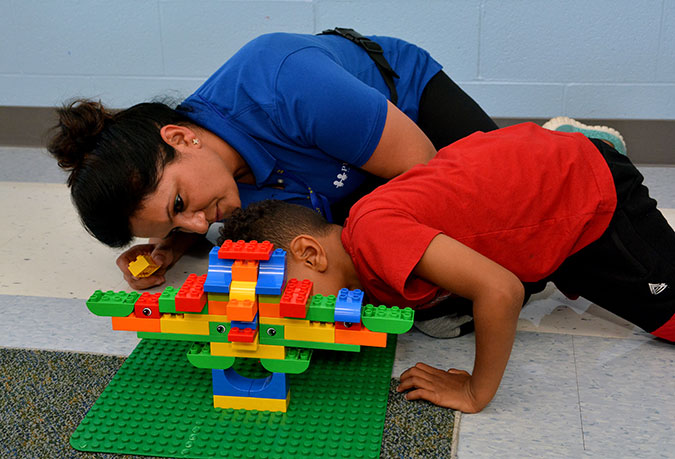 A child in a PLASP program with staff