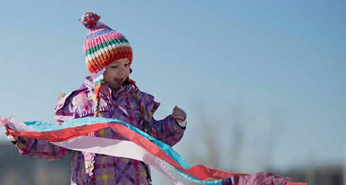 A child in winter clothing playing outdoors