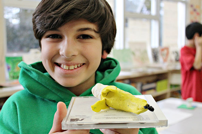 A child shows off a plasticine banana creation