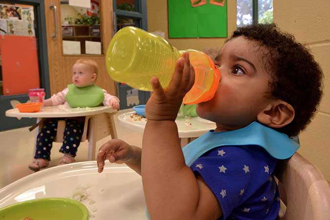 A child takes a sip from a plastic bottle