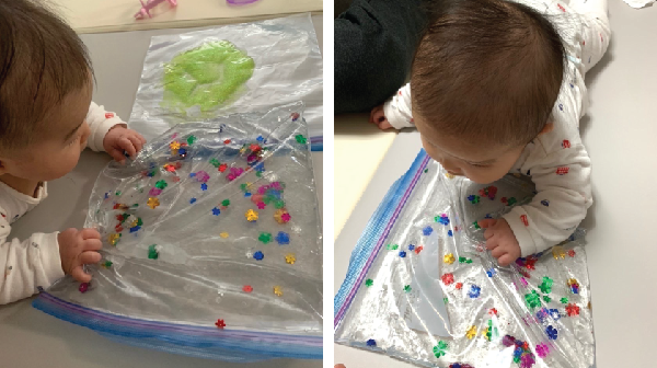 Infant touching bag filled with colourful toys