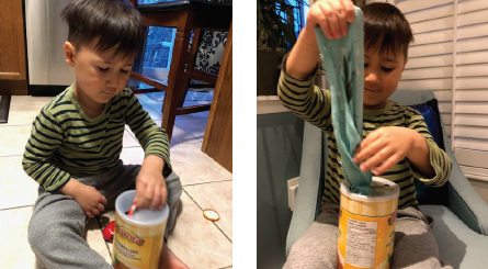 Boy puts objects through a hole in the lid of a canister